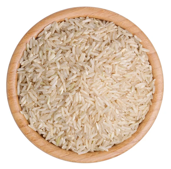 Вид сверху на сырой коричневый рис в деревянной миске изолирован — стоковое фото
