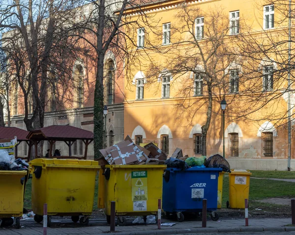 Timisoara, Romanya-26 Şubat 2020: ülkenin batısındaki en büyük şehrin merkezinde ağzına kadar dolu sarı ve mavi çöp tenekeleri