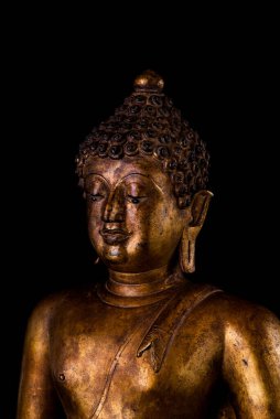 Antik Budist heykelinin portre resmi izole edilmiş siyah arka planda sağ tarafa dönüyor. Altından yapılmış heykel. Asya 'nın ruhani, barışçıl ve kültürel sembolü..