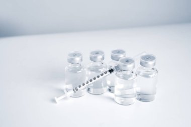 Empty bottle of vaccine with syringe for hygiene injection. Pharmaceutical equipment protective infection of pandemic covid-19 virus, flu, disease. Isolated on white background, copy space.