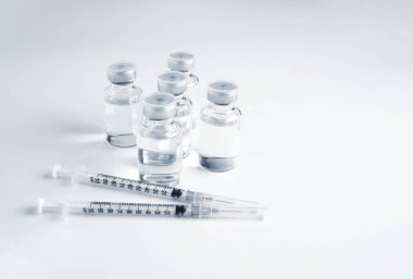 Empty bottle of vaccine with syringe for hygiene injection. Pharmaceutical equipment protective infection of pandemic covid-19 virus, flu, disease. Isolated on white background, copy space.
