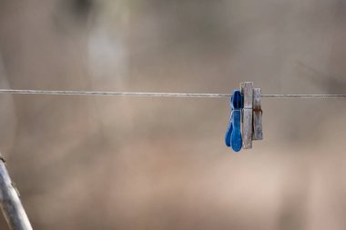 Bahçeyi genişleten ve üzerine farklı renk ve boyutlarda askılar koyan bir ipte arka plan bulanıklaşır.