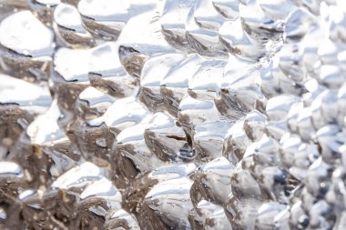 Su, büyük bir loş gibi parlayan ve ilginç bir desen oluşturan, kritik bir buz parçasıdır.