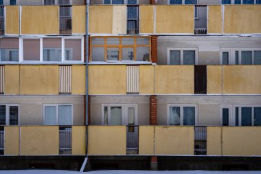 Letonya kırsalında, birçok balkon ve pencerenin görülebildiği Sovyet döneminden kalma bir binanın cephesi.
