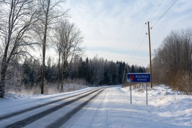 Kışın soğuk günbatımında siyah asfalt donmuş görünüyor.