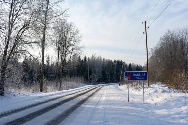 Kışın soğuk günbatımında siyah asfalt donmuş görünüyor.
