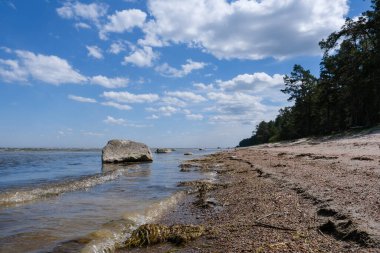 Blatia sahili, kumlu kayalık bir plaj ve güzel gökyüzü.
