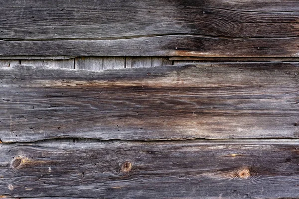 close-up of an old plank wall with old paint and the joints of the boards form lines that look close-up as a texture