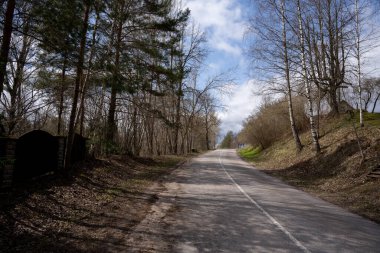Güneşli bir günde tepeye çıkan asfalt yolda.