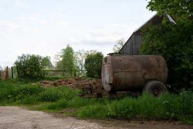 Ahırın yanında gübre yığınının yanında büyük metal bir varil duruyor.