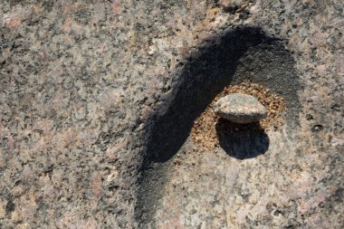 Büyük bir taşın üzerinde küçük bir çukur var.