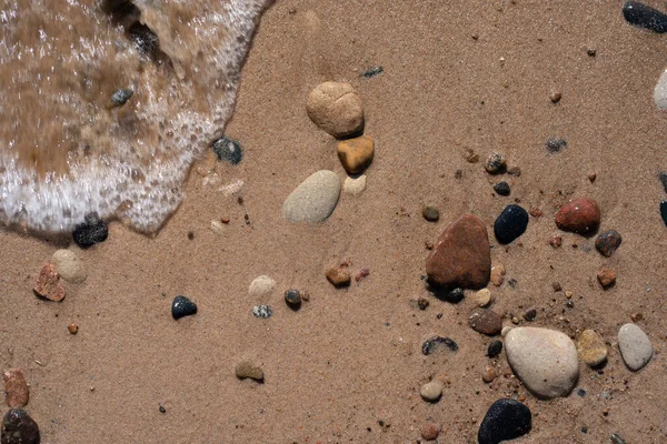 バルト海沿岸の湿ったビーチにはさまざまな色の小石があります — ストック写真