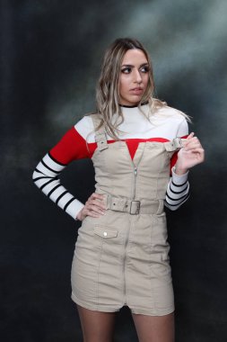 Güzel, göz kamaştırıcı sarışın kız izole arka planda stüdyoda poz veriyor. Tarz, trendler, moda konsepti.