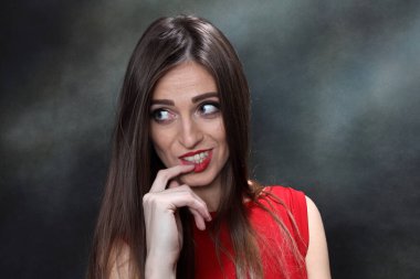 Güzel, pozitif esmer kız stüdyoda tuvalin arka planında poz veriyor. Rahatlama, zarafet, moda konsepti.