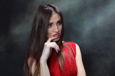 Güzel, pozitif esmer kız stüdyoda tuvalin arka planında poz veriyor. Rahatlama, zarafet, moda konsepti.