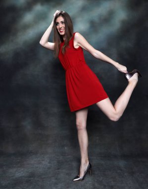 Güzel, pozitif esmer kız stüdyoda tuvalin arka planında poz veriyor. Rahatlama, zarafet, moda konsepti.