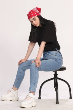 Siyah saçlı, gözlüklü, beyaz tenli güzel bir kız stüdyoda poz veriyor. Tarz, trendler, moda konsepti.