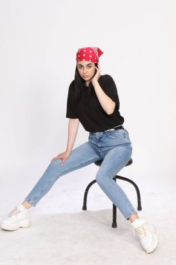 Siyah saçlı, gözlüklü, beyaz tenli güzel bir kız stüdyoda poz veriyor. Tarz, trendler, moda konsepti.