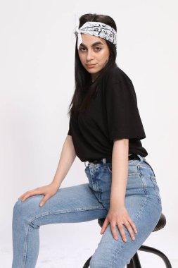 Siyah saçlı, gözlüklü, beyaz tenli güzel bir kız stüdyoda poz veriyor. Tarz, trendler, moda konsepti.