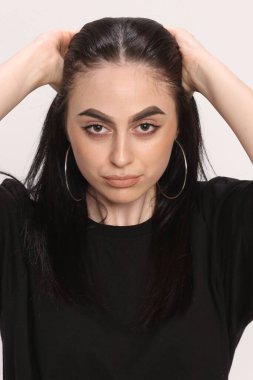 Siyah saçlı, gözlüklü, beyaz tenli güzel bir kız stüdyoda poz veriyor. Tarz, trendler, moda konsepti.