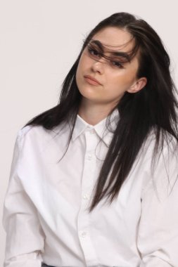 Siyah saçlı, gözlüklü, beyaz tenli güzel bir kız stüdyoda poz veriyor. Tarz, trendler, moda konsepti.