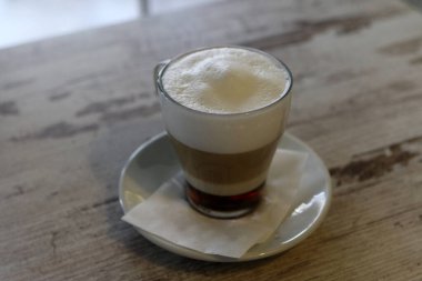 Kahve zamanı. Masada sıcak latte servis ediliyor. Yiyecek ve içecek konsepti.