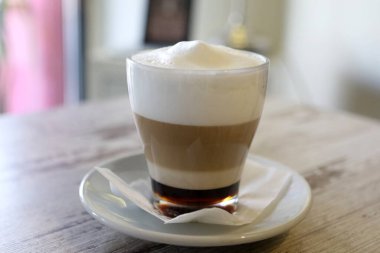 Kahve zamanı. Masada sıcak latte servis ediliyor. Yiyecek ve içecek konsepti.