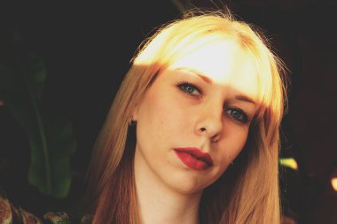 Mavi gözlü güzel sarışın kız poz veriyor. Sert ışık fotoğrafçılığı.