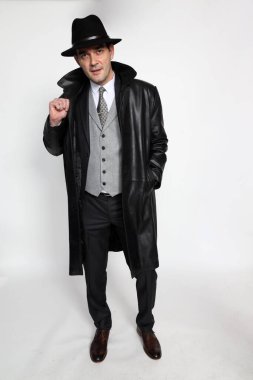 Soyutlanmış arka planda poz veren orta yaşlı yakışıklı bir gangster. Tarz, zarafet, iş, beyefendi, moda konsepti.