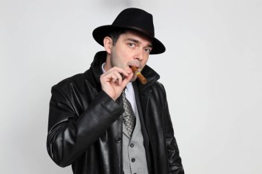 Soyutlanmış arka planda poz veren orta yaşlı yakışıklı bir gangster. Tarz, zarafet, iş, beyefendi, moda konsepti.