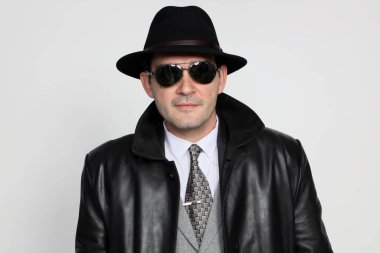Soyutlanmış arka planda poz veren orta yaşlı yakışıklı bir gangster. Tarz, zarafet, iş, beyefendi, moda konsepti.