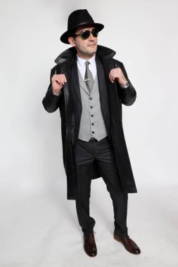 Soyutlanmış arka planda poz veren orta yaşlı yakışıklı bir gangster. Tarz, zarafet, iş, beyefendi, moda konsepti.