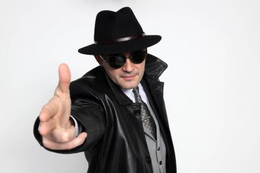 Soyutlanmış arka planda poz veren orta yaşlı yakışıklı bir gangster. Tarz, zarafet, iş, beyefendi, moda konsepti.