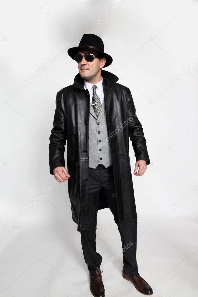 Handsome middle aged  gangster man posing in studio on isolated background. Style, elegance, business, gentleman, fashion concept.