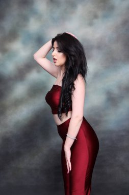 Güzel, beyaz tenli, uzun dalgalı saçlı, izole edilmiş arka planda poz veren bir kız. Tarz, trendler, moda konsepti.