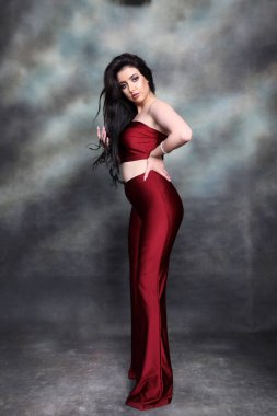 Güzel, beyaz tenli, uzun dalgalı saçlı, izole edilmiş arka planda poz veren bir kız. Tarz, trendler, moda konsepti.