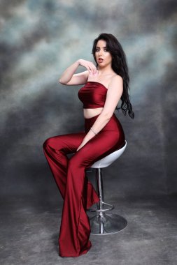 Güzel, beyaz tenli, uzun dalgalı saçlı, izole edilmiş arka planda poz veren bir kız. Tarz, trendler, moda konsepti.