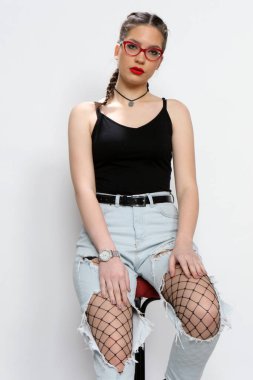 Stüdyoda izole edilmiş arka planda poz veren çekici beyaz bir kız. Tarz, trendler, moda konsepti.