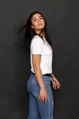 Güzel beyaz tenli esmer kız izole bir arka planda stüdyoda poz veriyor. Eğilimler, tarz, iyi zaman, moda kavramı.