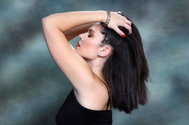 Siyah saçlı çekici kız stüdyoda poz veriyor. Tarz, trendler, moda konsepti.