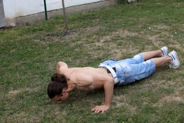 Yakışıklı, beyaz bir adam doğada spor yapıyor. Jimnastik, sağlıklı yaşam tarzı konsepti.