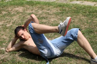 Yakışıklı, beyaz bir adam doğada spor yapıyor. Jimnastik, sağlıklı yaşam tarzı konsepti.