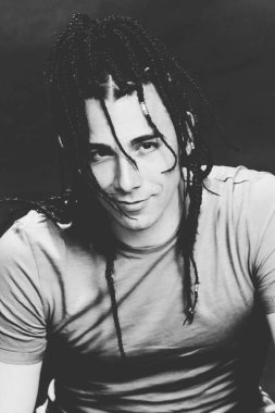 İzole edilmiş arka planda afro örgülü şık erkek model. Tarz, trendler, moda konsepti.