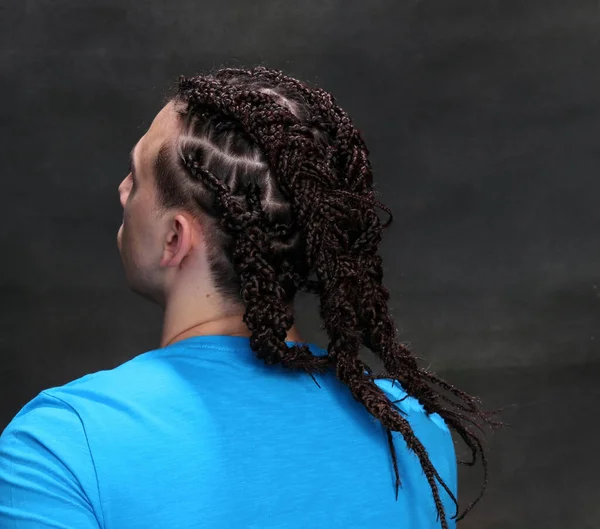 İzole edilmiş arka planda afro örgülü şık erkek model. Tarz, trendler, moda konsepti.