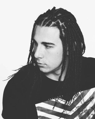 İzole edilmiş arka planda afro örgülü şık erkek model. Tarz, trendler, moda konsepti.