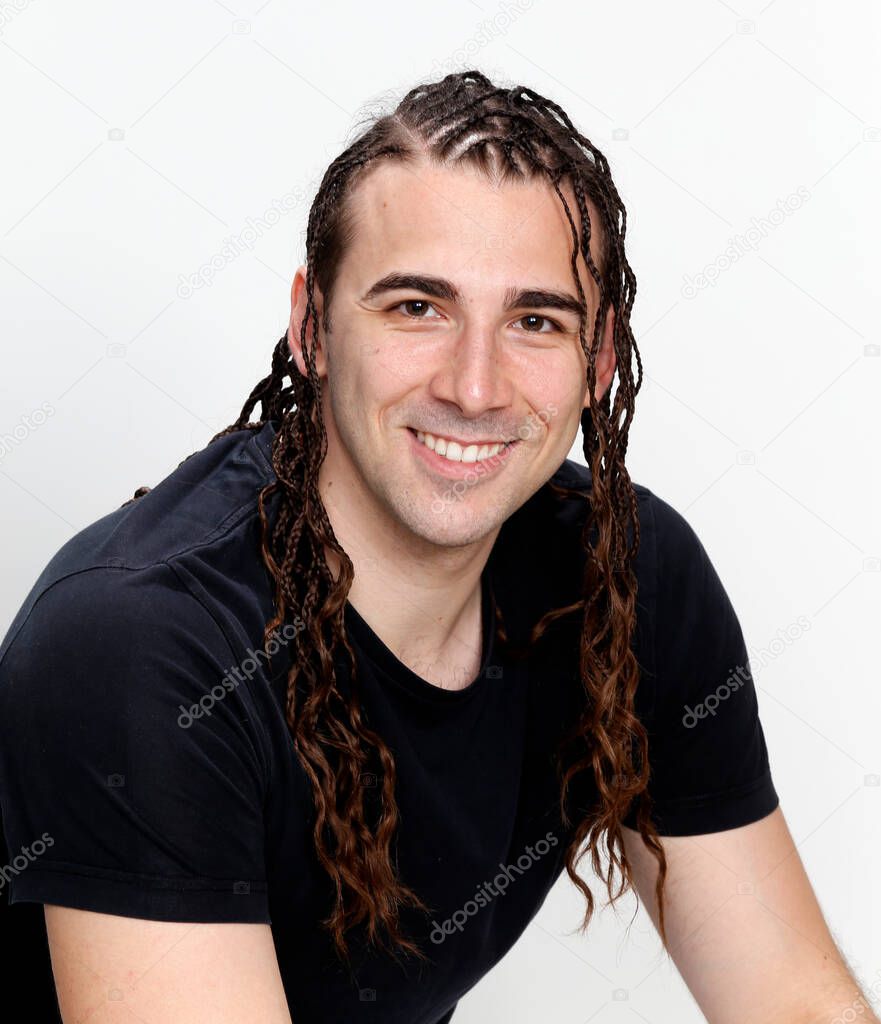 Attractive guy with braids posing in studio on isolated background. Style, trends, fashion concept.