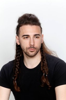 İzole edilmiş arka planda saç örgüleri olan şık bir erkek model. Tarz, saç stili, moda konsepti.