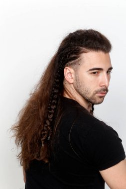 İzole edilmiş arka planda saç örgüleri olan şık bir erkek model. Tarz, saç stili, moda konsepti.