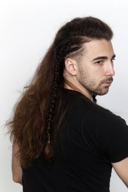 İzole edilmiş arka planda saç örgüleri olan şık bir erkek model. Tarz, saç stili, moda konsepti.
