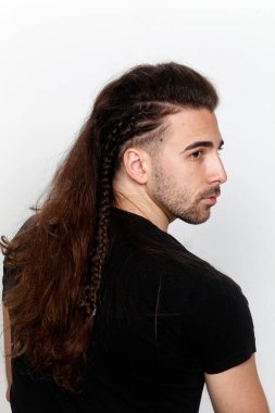 İzole edilmiş arka planda saç örgüleri olan şık bir erkek model. Tarz, saç stili, moda konsepti.